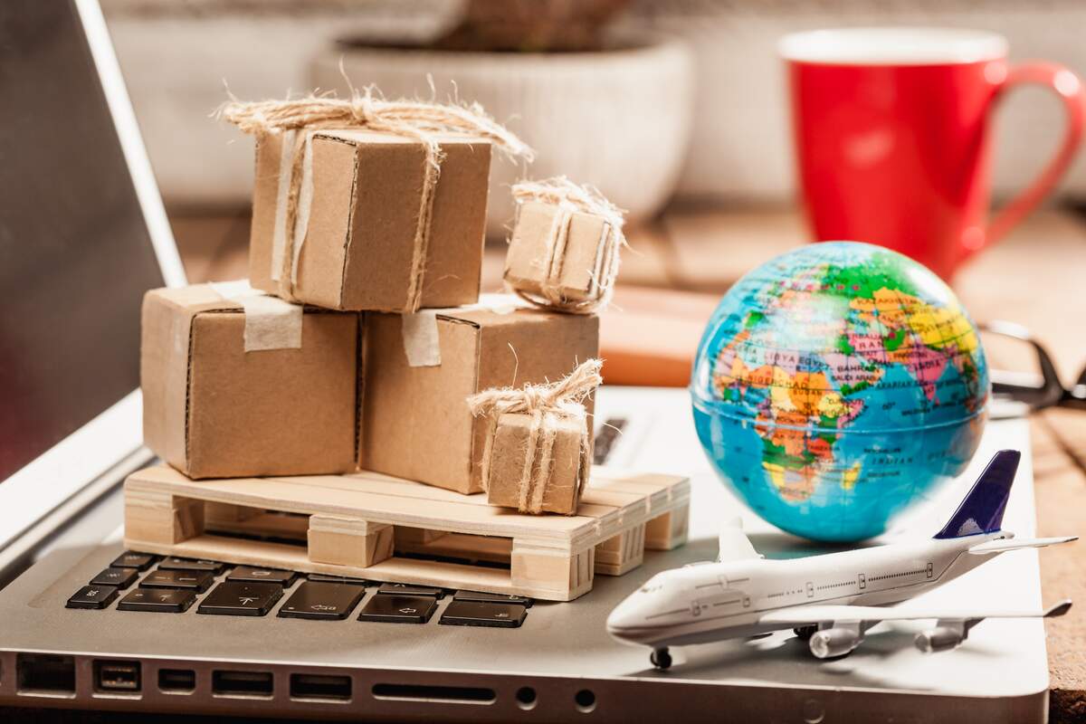 A globe surrounded by boxes and a plane, symbolizing international logistics and shipping operations